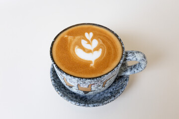 Close up shot of hot coffee latte art on wood table in cafe