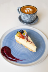 Close-up of a slice of cheesecake on a plate on a table in a cafe.