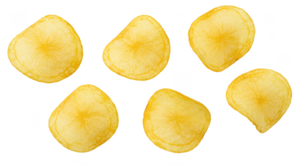 A group of six yellow gnocchi pieces arranged on a black background in a scattered formation showing texture