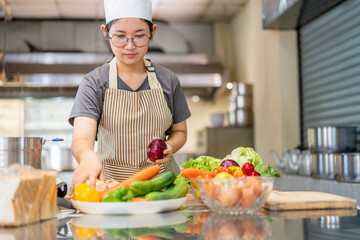 Young Female Chef Preparing Fresh Vegetables in Professional Kitchen