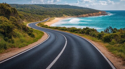 Scenic coastal road winds along a beautiful beach. Lush greenery borders the highway, hugging a picturesque shoreline. Turquoise waves crash against the shore