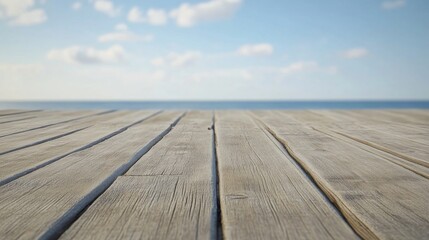 Wooden plank floor on sandy beach with calm ocean waves and clear blue sky in summer, ideal natural background for product display or coastal design mockup
