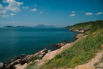 Obraz premium The sky above the island was a brilliant blue, with clouds drifting lazily over the ocean, as the clear water met the beach, creating a perfect natural paradise by the sea.