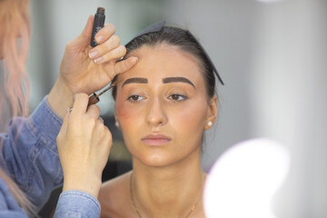 Fototapeta premium Makeup artist eyebrow shaping with brush.