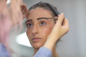 Makeup artist  eyebrow shaping with brush.