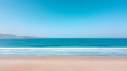 Fototapeta premium Tranquil Beach Scene: Azure Ocean Meets Golden Sand Under a Clear Blue Sky