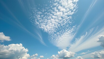 Bright blue sky featuring fluffy white cumulus clouds and delicate, feather-shaped cirrus clouds, creating a serene and airy atmosphere on a sunny day