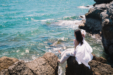 The woman enjoyed a solo travel vacation, basking in the summer sun on the beach, surrounded by nature, and embracing the freedom of a peaceful holiday getaway.