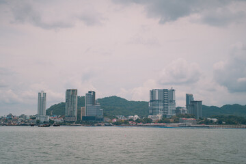 Fototapeta premium The city's skyline blends striking architecture and tall buildings beneath a vast sky, offering a sea view where water meets land a perfect panorama for travel tourism.