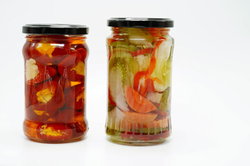 Pickles peppers tomatoes carrots chili homemade food in vase isolated at white
