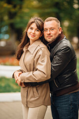 Fototapeta premium Couple enjoying a sunny day in a park while embracing and posing together