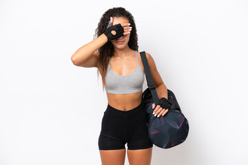 Young sport Arab woman with sport bag isolated on white background covering eyes by hands. Do not...