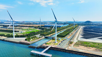 Aerial view of a hybrid power plant with wind turbines and solar panels