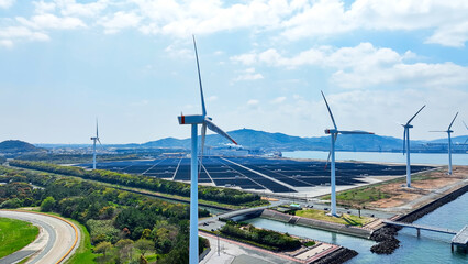 Aerial view of a hybrid power plant with wind turbines and solar panels