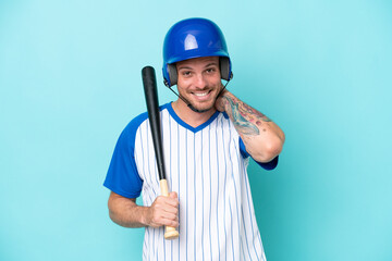 Baseball player with helmet and bat isolated on blue background laughing