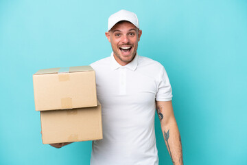 Delivery caucasian man isolated on blue background with surprise facial expression