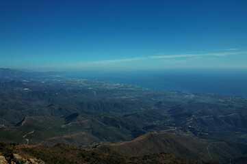 Breathtaking panoramic view of rolling hills meeting the mediterranean sea under a vast blue sky