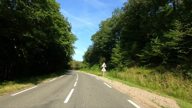 The driveway that runs through the lush countryside in Europe, France, Burgundy, Nievre, towards Chateau Chinon, in summer, on a sunny day.&nbsp;