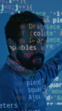 Vertical close-up of middle-aged bearded Caucasian male coding teacher explaining algorithm rules while conducting programming lesson at college, in blue light, with words, letters projected over face