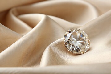Beautiful shiny diamond on beige silky fabric, close-up. Space for text (Diamond)
