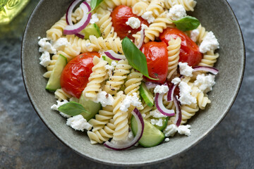 Fusilli, cucumber, roasted tomatoes and cottage cheese pasta salad, horizontal shot, middle close-up