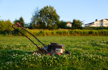 Lawn mover on green grass background. Machine for cutting lawns. Garden care. Electric equipment....