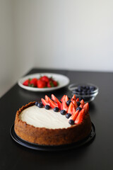 freshly baked classic cheesecake with strawberries and blueberries