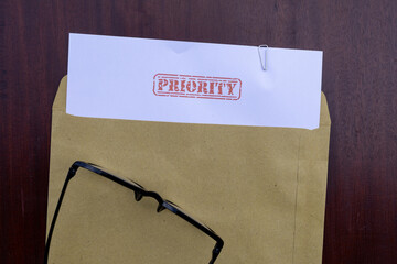 Priority Mail Visual: Document in Envelope on Brown Wooden Surface