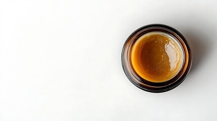 Top down view of amber glass jar filled with golden brown liquid