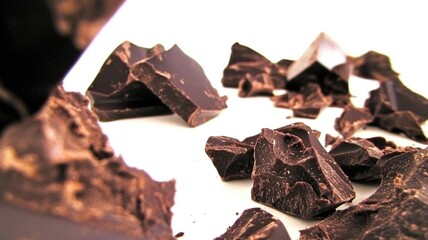 Chunks of broken chocolate laid on a surface, offering a close-up of its rich texture.