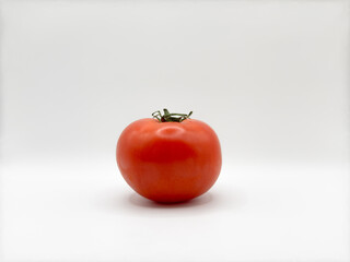 Red bright juicy tomato on a white background in the center of the image one without unnecessary objects front view