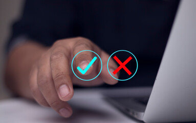 Businessman thinking and deciding between right and wrong symbols. Voting decision concept. Voting yes or no. Decision making in crisis situation. Businessman making choice in difficult situation.