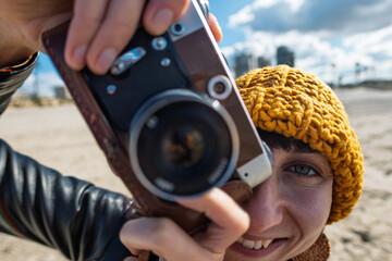 Woman taking photos outdoors. close-up of camera. Young beautiful girl creating content while...