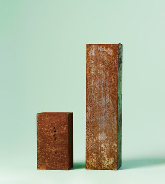 Rusty metal blocks against a pastel green background