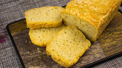 Golden crusty bread loaf with slices placed artistically on a rustic wooden board ready for serving