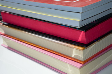 colorful stack hardcover books detailed textures pages natural light modern feel bookstore library...