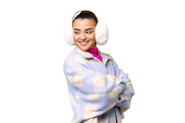 Young woman wearing winter muffs over isolated chroma key background with arms crossed and happy
