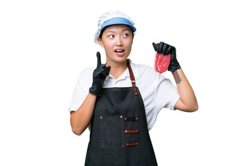 Young caucasian woman wearing an apron and serving fresh cut meat over isolated background thinking an idea pointing the finger up