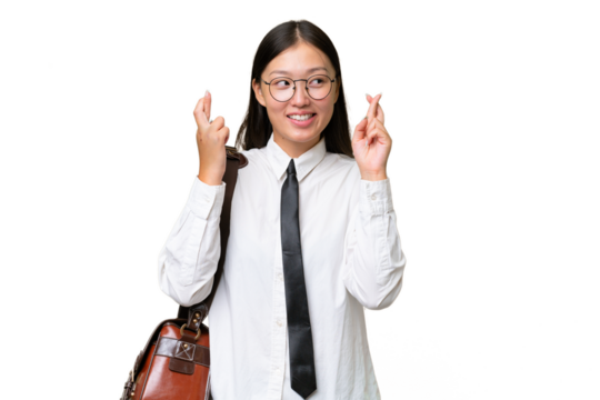 Young Asian business woman over isolated background with fingers crossing
