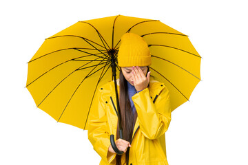 Young Asian woman with rainproof coat and umbrella over isolated chroma key background with tired...