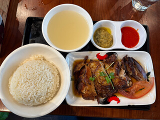A meal of rice, soup, and roast chicken.