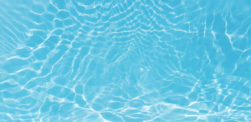 Blue water with ripples on the surface. Defocus blurred transparent blue colored clear calm water surface texture with splashes and bubbles. Water waves with shining pattern texture background.