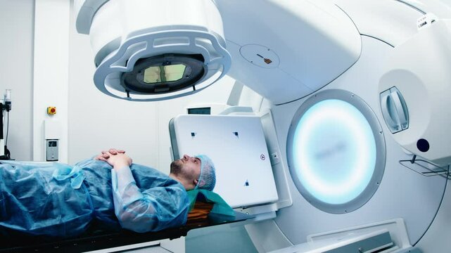Cancer treatment in a modern medical private clinic or hospital using a linear accelerator. A young male undergoing radiation therapy for cancer. Concept of modern medical technology.