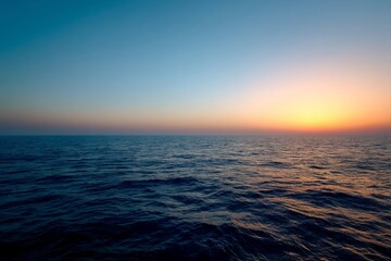 Obraz premium Ocean Sunset: Waves Reflecting Golden Hues, Tranquil Seascape at Dusk, Serene Water, Colorful Sky, Peaceful Evening, Horizon View, Calm Waters, Natural Beauty, Breathtaking Scenery, Twilight Glow