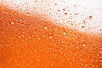 background texture for background bright orange, yellow, sunny color, peach color with shimmering elements and flowing drops on glass, beautiful bright background with overflows and gradient