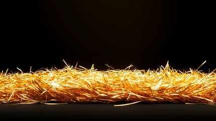 Shiny golden tinsel garland on a dark surface, catching light and creating a festive feel