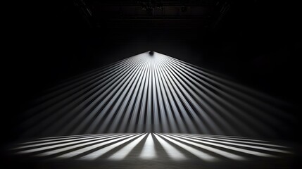 A dark room is illuminated by a single light source above, casting numerous, sharply defined rays of light onto the floor, creating a striking pattern of alternating light and shadow.