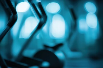 Gym exercise equipment in a fitness center.  Blurred focus on stationary elliptical trainers