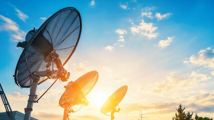 Satellite Communication Dishes Against a Bright Sunset Sky Broadcasting
