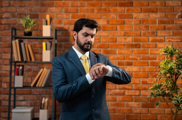 Focused CEO adjusts his watch, staying punctual and prepared in a stylish corporate setting